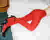 woman lying across a bed wearing red tights. The image is focused on the tights.